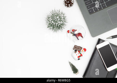 Buon Natale e felice anno nuovo ufficio spazio di lavoro desktop concetto. Flat Top laici vista con laptop notebook e ornamenti Natale con copia spazio. Foto Stock