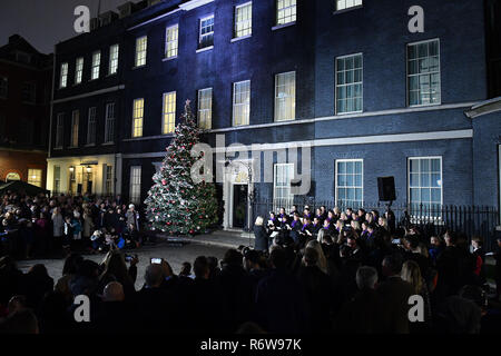 Carol cantanti di eseguire a Downing Street, Londra per l'albero di Natale interruttore luce on. Foto Stock