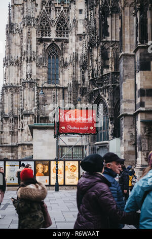 Vienna, Austria - 24 Novembre 2018: la gente camminare passato segno direzionale al mercatino di Natale in stallo vicino al Duomo di Santo Stefano, il più importante rel Foto Stock