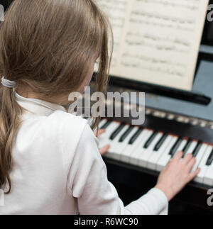 Bambina di imparare a suonare il pianoforte. Foto Stock