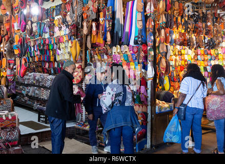 Il souk di Marrakech - Donne shopping nella medina di Marrakech, acquistare scarpe colorate e pantofole, Marrakech, Marocco Foto Stock