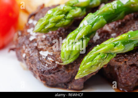 Bistecca di manzo e asparagi verdi su una piastra Foto Stock