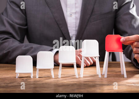 Mano umana azienda sedia rossa Foto Stock