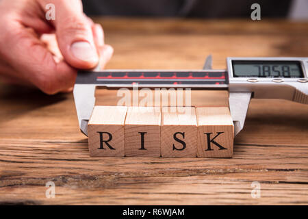 Mano umana la misurazione del rischio di blocchi di legno Foto Stock