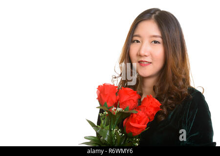 Felice giovane donna asiatica holding rose rosse pronto per San Valentino Foto Stock