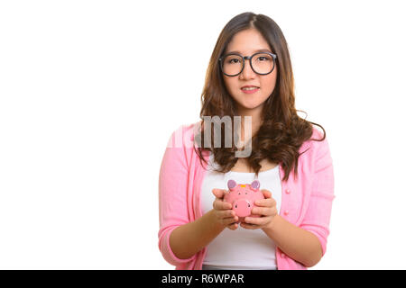 Felice giovane donna asiatica holding salvadanaio Foto Stock