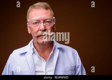L'uomo anziano medico o scienziato che indossa gli occhiali di protezione Foto Stock
