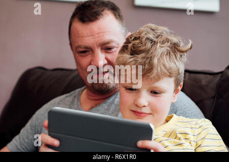 Giocando su una tavoletta digitale con il papà Foto Stock