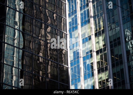 Colpo artistico di due torri di uffici nel centro di core con diversi design e affrontando con una riflessione di edifici circostanti Foto Stock