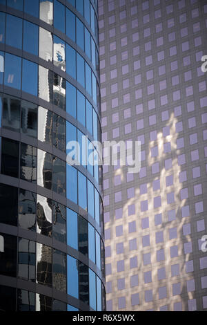 Colpo artistico di due torri di uffici nel centro di core con diversi design e affrontando con una riflessione di edifici circostanti Foto Stock