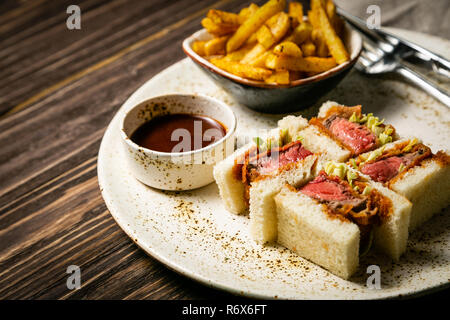 Sando Katsu - cibo giapponese di tendenza panino con carne di maiale e patatine fritte Foto Stock