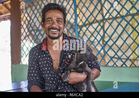 Uomo indiano con il suo cucciolo nei suoi ristoranti Foto Stock