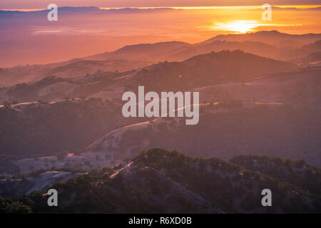 Splendide colline immerso nella luce del tramonto; il sole al tramonto riflesso nell'acqua della baia di San Francisco in background; vista da Mt ha Foto Stock