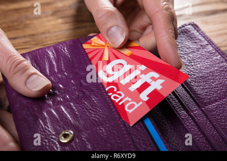 Mano umana rimuovendo la Carta regalo da borsa Foto Stock