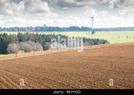 Grandi campi di colore marrone del terreno fertile e verde bosco in background Foto Stock