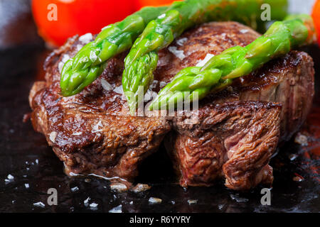 Il filetto di manzo e asparagi verdi in una padella Foto Stock