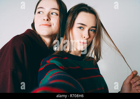 Due sorelle gemelle belle ragazze in casuale tenendo selfie su fro Foto Stock