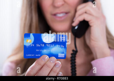 Donna di mano azienda Carta di Credito mentre si parla al telefono Foto Stock