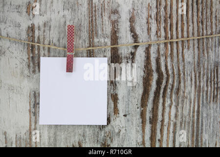 Nota vuota appeso con un clothespin, in uno sfondo di legno Foto Stock