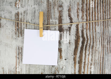 Nota vuota appeso con un clothespin, in uno sfondo di legno Foto Stock