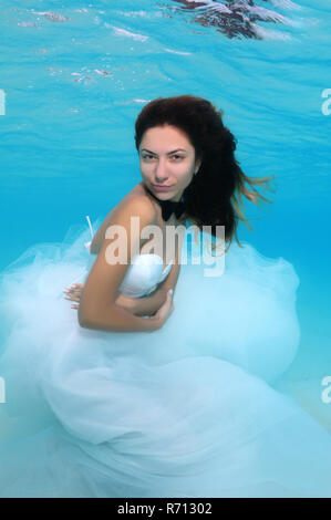 Giovane bella ragazza in un abito da sposa subacquea, Oceano Indiano, Maldive Foto Stock
