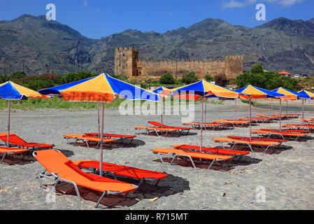 Pittoresca spiaggia di sedie a sdraio e ombrelloni nella parte anteriore del castello di Frangokastello, Creta, Grecia Foto Stock