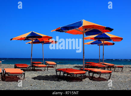 Pittoresca spiaggia di sedie a sdraio e ombrelloni sulla spiaggia, mare blu, Creta, Grecia Foto Stock