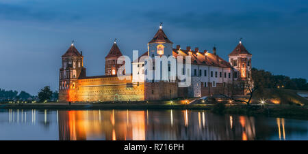 Mir, Bielorussia. Vista panoramica del complesso del Castello di Mir In illuminazione serale con candelette di riflessioni sul lago di acqua. UNESCO Patrimonio dell'Umanità. Famoso punto di riferimento, un Foto Stock