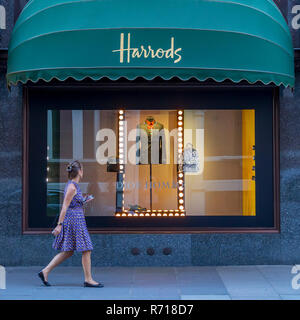 Passante di fronte alla vetrina di un negozio, i grandi magazzini Harrods, Londra, Gran Bretagna Foto Stock