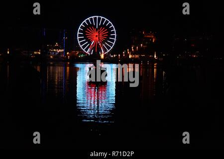 Lucerna di notte, ruota panoramica illuminata come un cuore rosso. Foto Stock