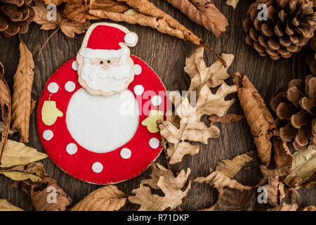 Fatte a mano Santa Claus Mug Mat, marrone su sfondo di legno Foto Stock