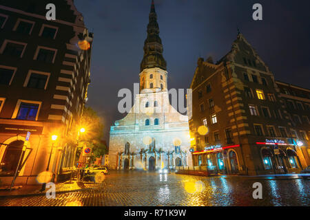 Riga, Lettonia - 4 Luglio 2016: vista notturna della chiesa di San Pietro nella Città Vecchia di Riga in Lettonia. Strada illuminata. Foto Stock