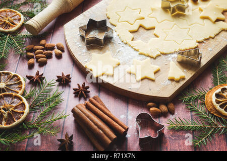 Ingredienti per la produzione di biscotti di Natale. Perno di rotolamento cookie cutters cannella farina burro Uova impasto su sfondo chiaro con spazio di copia Foto Stock