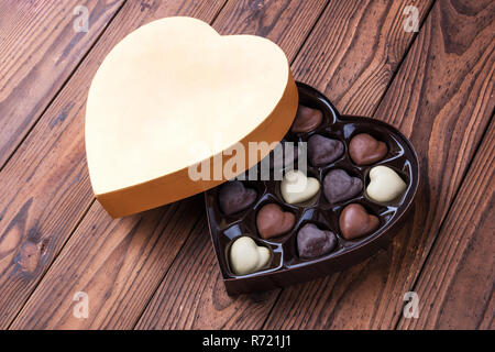 Il giorno di San Valentino dono di oro a forma di cuore ad una scatola di  cioccolatini appoggiata sulla scatola cuore top dando un doppio effetto di  cuore Foto stock - Alamy