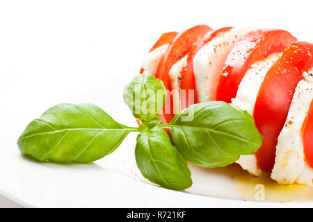 Il motorino di avviamento Italiano chiamato 'insalata caprese è un mix di pomodori a fette di mozzarella, basilico e condite con sale e pepe e olio di oliva. Foto Stock