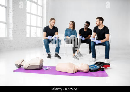 Un gruppo di giovani seduti durante il primo aiuto alla formazione in aula in bianco Foto Stock