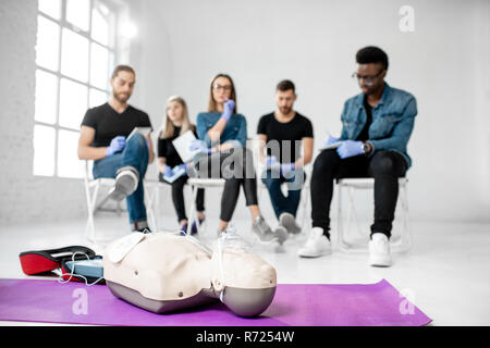 Materiale medico per formazione di primo soccorso con un gruppo di giovani sullo sfondo Foto Stock