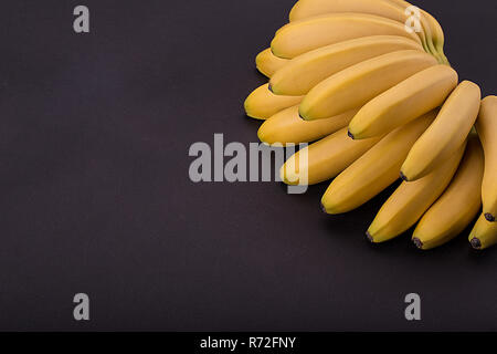 Il ramo baby banane su sfondo nero. Foto Stock