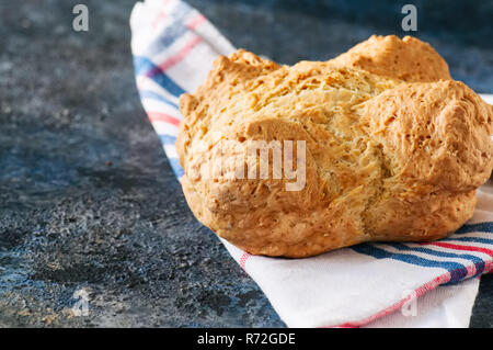 Irlandese tradizionale pane soda su un asciugamano su una pietra blu sullo sfondo. Foto Stock