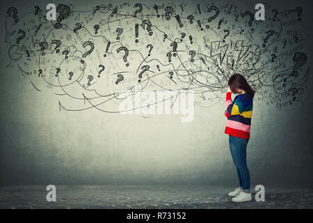 Vista laterale a piena lunghezza Ritratto di preoccupato giovane donna tenendo la mano verso la fronte. Riflessivo ha sottolineato ragazza triste emozione meditativa con un pasticcio nella sua hea Foto Stock