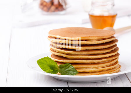 Frittelle americane pila servita con frutti e sciroppo d'acero bianco sullo sfondo di legno family Colazione snack Foto Stock