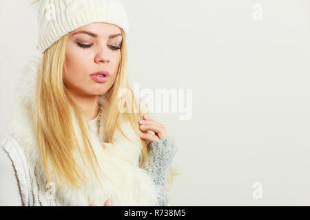 Inverno moda. Giovane donna bionda che indossa moda inverno abiti pelliccia bianca sciarpa, cappello di lana e guanti, studio shot Foto Stock