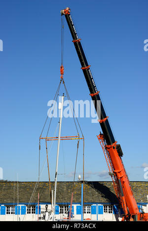 Gru essendo utilizzato per sollevare barche al di fuori dell'acqua a Paignton Porto. Foto Stock