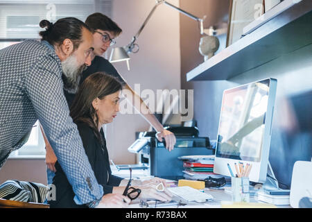 Giovane lavora con il figlio in home office Foto Stock