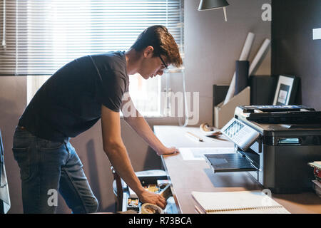 Uomo che lavora in ufficio a casa Foto Stock