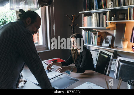 Giovane lavorando in ufficio in casa Foto Stock