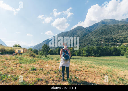 Giovani femmine escursionista guardando verso le montagne, vista posteriore, Primaluna, Trentino-Alto Adige, Italia Foto Stock