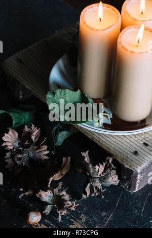 Candele accese su rustiche tagliere Foto Stock