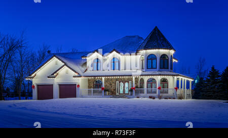 Una grande casa illuminata di notte nei pressi di Winkler, Manitoba, Canada. Foto Stock