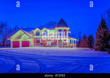 Una grande casa illuminata di notte nei pressi di Winkler, Manitoba, Canada. Foto Stock